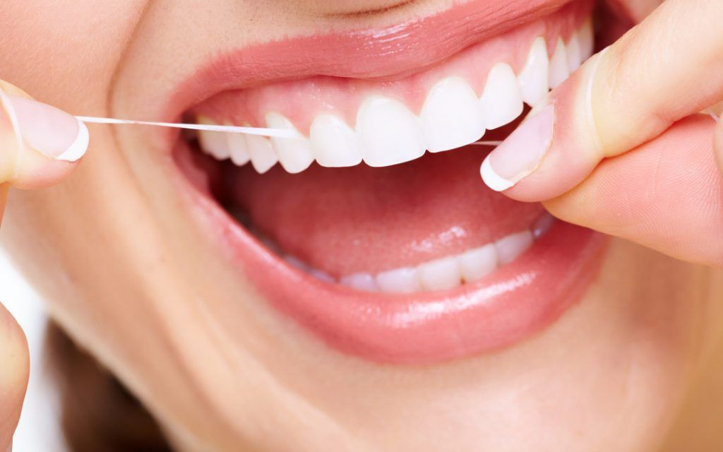 Mujer con seda dental