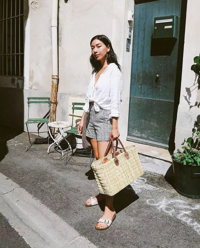 Camisa anudada con pantalones cortos, sandalias y bolso