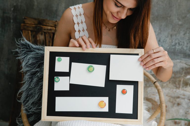 woman holding a small magnetic board with blank pieces of paper stuck to it