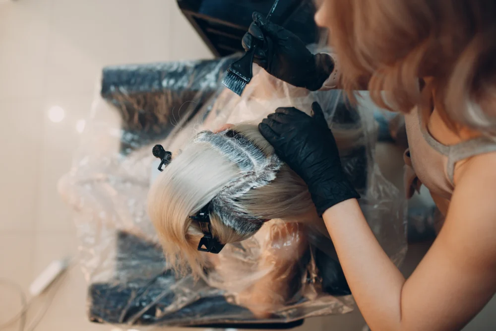 Cuenco con producto decolorante y paletina en una peluquería